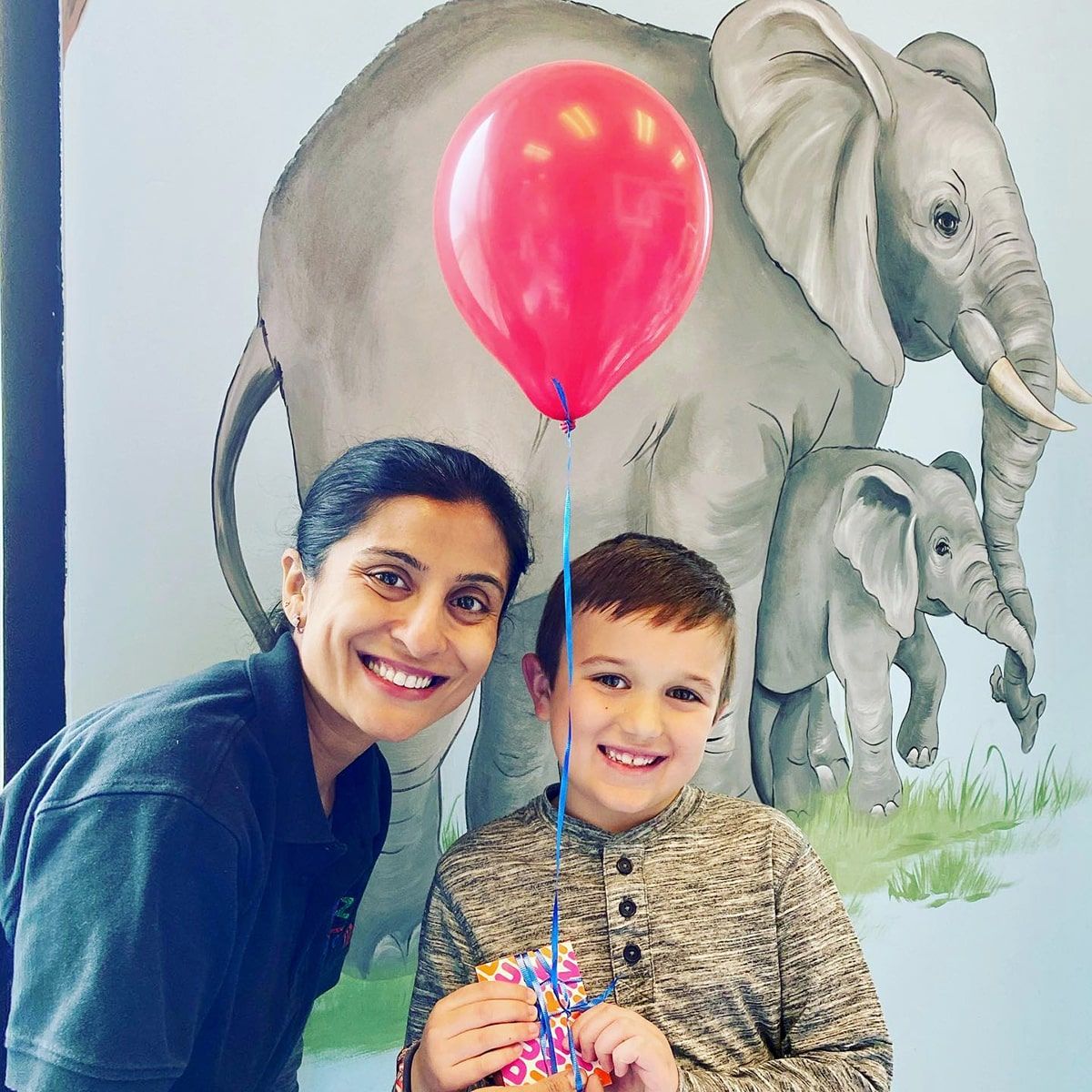 child with balloon and dentist