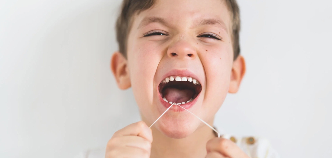 child flossing teeth